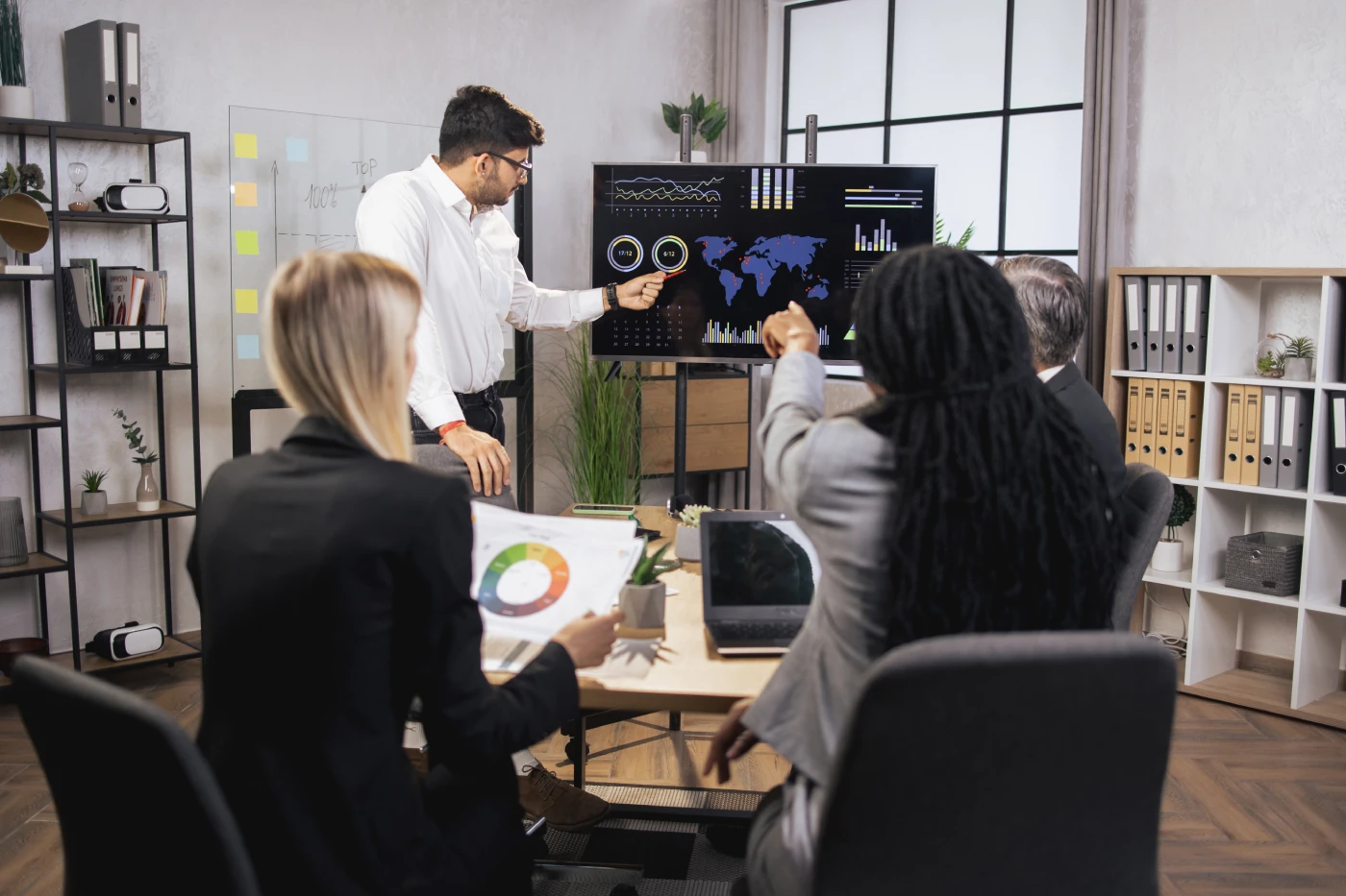 Team analyzing charts on screens